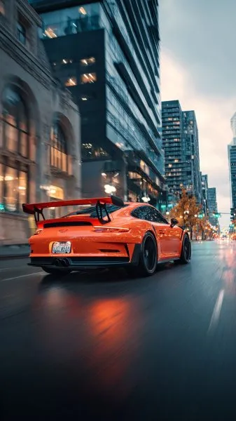 Яркий оранжевый Porsche 911 в городском потоке: динамика и стиль. Картинка из нейронной сети Midjourney