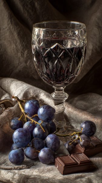Изысканная композиция: вино, шоколад и гроздья винограда. Картинка из нейросети Миджорни