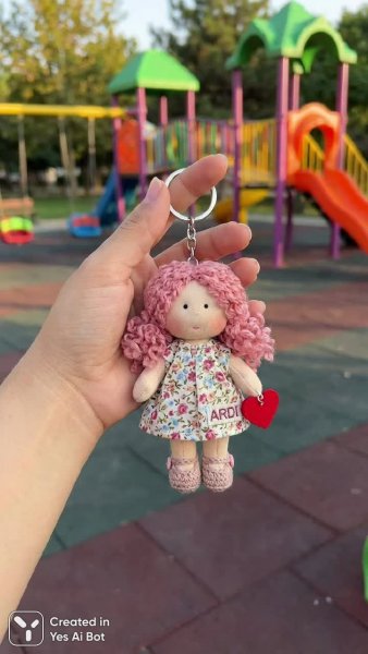 Милая кукла на брелоке: нежность в деталях и яркий фон детской площадки. Генерация из нейросети Нано Банана